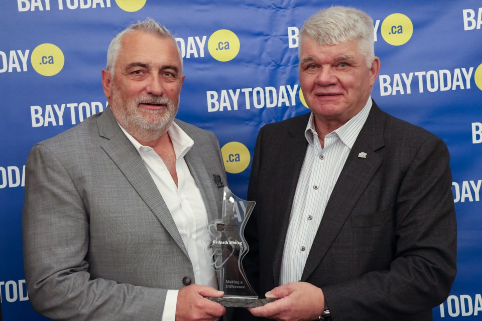 Paul Healy and George Flumerfelt holding Community Builders Award trophy.