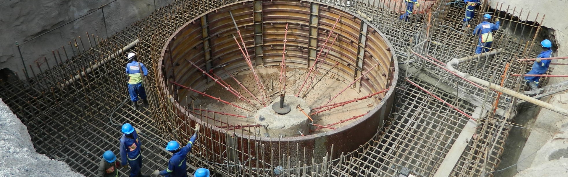 Los empleados de Redpath trabajan en un sitio excavado, construyendo una red de vigas resistentes en preparación para construir una estructura sustancial de hormigón.